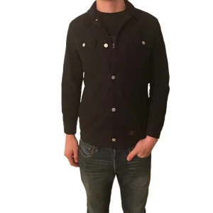 Overshirt jacka svart S - Svart vadderad overshirt jacka från H&M med riktigt skön passform! Säljs inte längre! Jackan har två bröstfickor och två sidofickor. Perfekt för dig som vill ha en varmare overshirt till hösten!     Längd: 67cm Bröstvidd: 50cm
