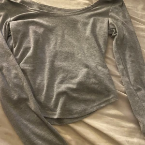 Grå långärmad topp från Dazy - Säljer en stilren grå långärmad topp från Dazy i storlek S. Toppen har en mjuk och skön känsla med rundad hals och kan ha den som off shoulder och smal passform. Perfekt att matcha med jeans eller kjol för en clean look. Materialet är troligtvis bomull eller polyester.