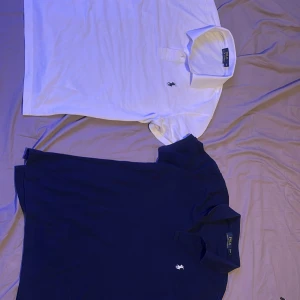 Två Polo Ralph lauren pikér. En mörkblå, En Vit. - Bra skick på tröjorna har bara slutat passa mig. Dem är i storlek M men är relativt små i storlekarna. Så om man är lite mellan M och S eller bara gillar när tröjorna sitter lite tightare så är detta ett perfekt köp för dig. Jag säljer dem som ett par. Men kan sälja en åt gången om man endast har intresse för en av dem. Bra skick med snygga färger . 