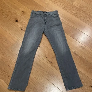 Grå jeans från Replay - Snygga grå jeans från Replay med klassisk femficksdesign och raka ben. Jeansen har en diskret tvättad look och tydliga sömmar vid fickor och benslut. Perfekta för dig som gillar en stilren och enkel vibe.