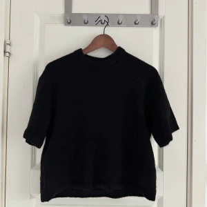 Svart stickad tröja från Gina Tricot - Svart stickad tröja från Gina Tricot med kort ärm och rund halsringning. Oanvänd. Passar även S/M🖤