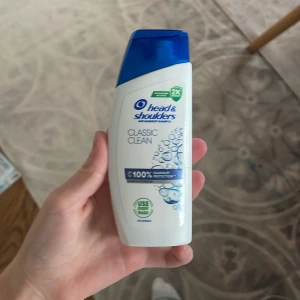 Head & Shoulders Classic Clean schampo - Head & Shoulders Classic Clean schampo i en vit plastflaska med blått lock. Flaskan har en modern, smal form och rymmer 95 ml. Märket är känt för sin anti-dandruff formula och fräscha doft. Perfekt för dig som vill ha rent och fräscht hår.