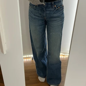 Weekday low loose jeans - Säljer ett par klassiska blå weekday med låg midja och raka, vida ben. Jeansen har fem fickor, knappgylf och den ikoniska läderpatchen bak i midjan. Perfekta för en avslappnad och trendig look. W24 L32, är 1,58cm för referens