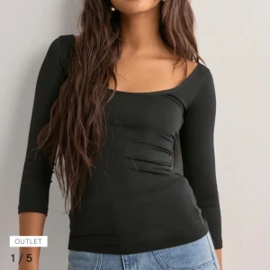 Svart långärmad topp med fyrkantig hals - Säljer en svart långärmad topp med snygg halsringning och tight passform. Toppen är enkel och stilren, perfekt att matcha med jeans eller kjol. Materialet känns mjukt och stretchigt mot huden.