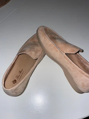 Beige mocka loafers från Loro Piana - Säljer ett par stilrena loafers från Loro Piana i beige mocka. Skorna kommer med originalförpackning, dustbag och tags. Perfekta för dig som gillar lyxiga och tidlösa skor.