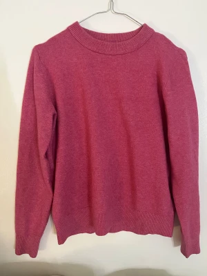 Rosa stickad tröja från M&S Collection - HELT OANVÄND!!!! Säljer en rosa stickad tröja från M&S Collection i storlek XS. Tröjan har en rund hals med ribbad kant och långa ärmar med ribbade muddar. Perfekt för dig som gillar mjuka och sköna plagg med enkel design.