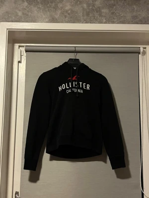 Svart hoodie från hollister  - Vi säljer nu en snygg svart hoodie från Hollister! Det står att den är storlek M men tyvärr har den krympt till s/xs under tvätt. Den är väldigt fin och finns inga synliga defekter✨ hör av er vid frågor!🤩