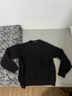 Mörkbrun stickad tröja Dressmann L - Säljer en mörkbrun stickad tröja från Dressmann i storlek L. Tröjan har ett klassiskt kabelstickat mönster, rund hals och långa ärmar. Perfekt för dig som gillar enkel och stilren design med lite extra struktur i materialet dessutom är det bra för kalla vintrar och kalla höst.