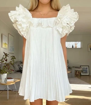 Vit kort plisserad klänning med volang - INTRESSEKOLL!! På denna så fina och sjukt eftertraktade klänningen från Zara, endast använd vid 1 tillfälle!!  Säljer endast vid bra pris så kom med prisförslag!!  ❤️❤️