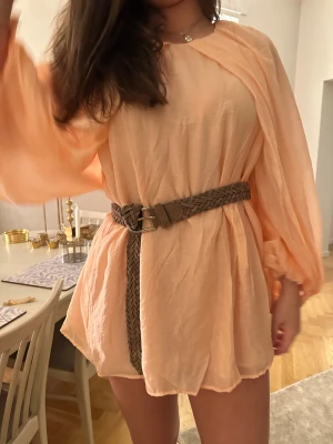 Ljusrosa mini klänning - Säljer en superfin ljus persikofärgad kortklänning med luftiga armar. 