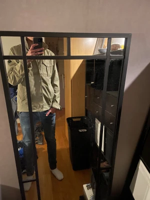 Olivgrön overshirt från J.Lindeberg - Säljer en beige overshirt från J.Lindeberg med snygga bröstfickor och silverfärgade knappar. Jackan har en rak passform, hög krage och dragkedja under knappslå. Perfekt att slänga på över en hoodie eller t-shirt för en chill look. Helt ny använd 2 gånger inga defekter alls 