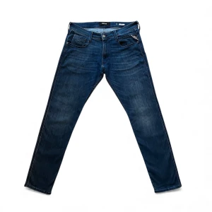 Mörkblå Replay Anbass jeans, W34 L32, Mycket bra skick - Mörkblå Replay Anbass jeans i slim fit. Använda men i mycket bra skick. Litet diskret hål (syns på sista bilden), märks knappt vid användning. Storlek: W34/L32 Mått finns i annonsen. Skicka meddelande vid frågor!