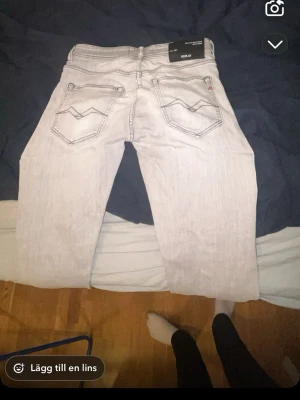Replay ljusa jeans med raka ben - Säljer ett par ljusa jeans från Replay med klassisk femficksdesign och raka ben. Jeansen har subtila slitningar och tydliga sömmar på bakfickorna. Passar dig som gillar en clean och stilren look. Materialet är jeans och färgen är ljusgrå.