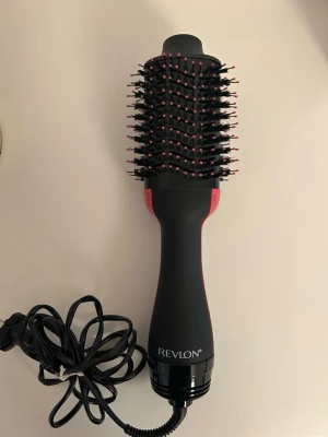 Revlon RVDR5222 One-Step Hair Dryer & Volumizer - Revlon RVDR5222 One-Step Hair Dryer & Volumizer med 2 värmelägen. Kombinerar hårtork och borste för enkel styling och volym. Fungerar med 220-240V, modell i gott skick utan synliga defekter eller slitage. 