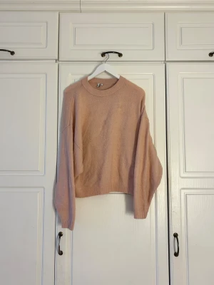 Ljusrosa stickad tröja från H&M💖 - Mysig ljusrosa stickad tröja från H&M med rund hals och ribbade muddar vid ärmslut och nederkant. Tröjan har en loose passform och långa ärmar, perfekt för att hålla sig varm under kyliga dagar. Enkel och stilren design som är lätt att matcha.