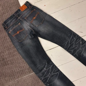 Mörkblåa Nudie Straight Alf Jeans - Riktigt snygga Nudie Jeans i Grim Tim | W28 L32 sitter som W29 | Nypris 1699kr | Riktigt fint skick, inga hål eller liknande. | Midja: 37-40cm (Stretch) längd: 106 | Tydliga fades och extremt sjuka honeycombs. | Skriv vid minsta fundering, pris ej hugget i sten! 