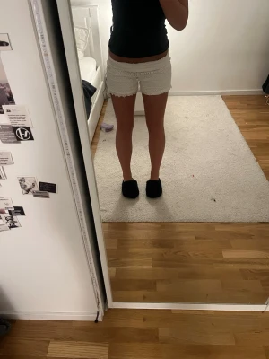 Spetsshorts från Vero Moda - Säljer ett par vita shorts från Vero Moda i storlek XS. De har snygg spets över hela. Det går att vika ner midjan som på bild 1 för att få dem lägre
