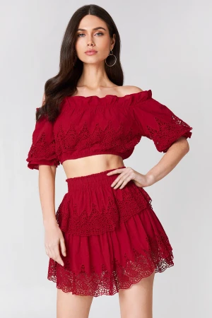 Linn Ahlborg x NA-KD Embroidery Set Top and Skirt - Röd topp och kortkjol från Linn Ahlborg x NA-KD med bred resår i midjan och flera lager volanger. Set med fina spetsdetaljer och en luftig känsla. Topp storlek 34, kjol storlek 36.