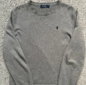 Polo Ralph Laurent stickad - Säljer en stilren grå stickad tröja från Polo Ralph Lauren.  Den är i nyskick. Perfekt för höst och vinter. Passar både till vardags och lite finare tillfällen. Modellen är 178 cm, skriv vid minsta lilla 🍾💯