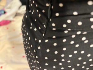 Svart prickig kortkjol med dragkedja - Säljer en svart kortkjol med vita prickar och en snygg dragkedja i sidan. Kjolen har en lätt utsvängd form som ger en skön och ungdomlig vibe. Materialet känns mjukt och följsamt, perfekt för dig som gillar att sticka ut med mönster.