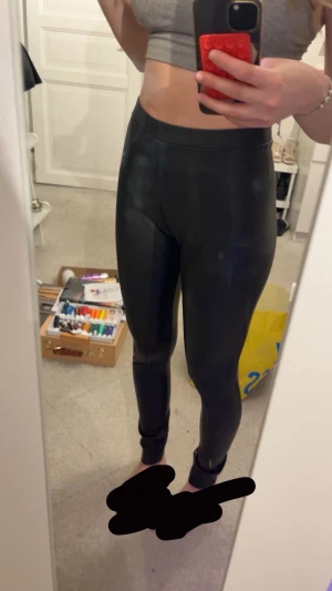 Svarta skinnleggings från Norfy - Säljer ett par svarta leggings från Norfy i storlek 36. De har en snygg, glansig skinnlook och är högmidjade med tight passform. Perfekta om du vill ha en edgy vibe och gillar att sticka ut lite extra. Superstretchiga och bekväma!
