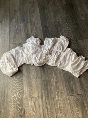 Vit kortärmad t-shirt i bomull - Säljer en vit t-shirt med korta ärmar, tillverkad i mjuk bomull. Enkel och klassisk design som funkar till det mesta. T-shirten har rund hals och är i en neutral vit färg, perfekt för dig som gillar basic plagg. 11 st.