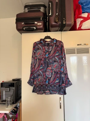 Odd molly blus  - Säljer en otroligt vacker blus med en marinblå bottenfärg och ett fint detaljerat mönster i blå, rött och vitt, Från märket Odd Molly. Storlek 3 som enligt deras storleksguide motsvarar en L. Mycket fint skick, jag hittar inga synliga anmärkningar eller defekter. 