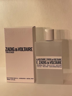 Zadig & Voltaire This Is Her -  Zadig & Voltaire This is her EDP .Top notes are Pink Pepper, Jasmine Sambac and Silkwood Blossom; middle notes are Whipped Cream, Vanilla and Chestnut; base notes are Sandalwood and Cashmere Wood.   100ml flaska vikt  344g flaska.  Denna flaska väger 339g alltså 5 ml är använt.  Nypris på Lyko för 100ml är 1080kr