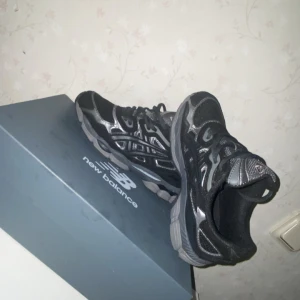 Svarta och silver Asics sneakers - Säljer ett par snygga Asics sneakers i svart och silver med coola detaljer och meshpaneler. Skorna har snörning och en platt sula som ger grym komfort. Perfekt för dig som gillar sportig stil och vill ha något som sticker ut. Ingen box tillkommer.