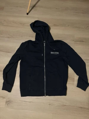 Marco polo Ziphoodie - Material: 100 % bomull. Plagget är endast använt ett par gånger och är köpt på Stockmann. Mått: – Axelbredd: 45 cm – Längd: 65 cm Ge gärna ett bud!