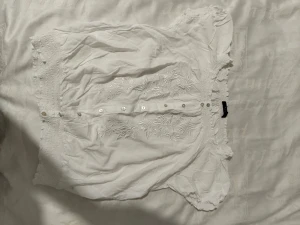 En jättefin blus. - En vit blus, som också kan bli en magtröja. Den är jättegullig, tyget är breath able