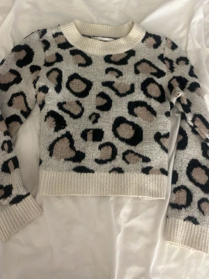 Leopardmönstrad stickad tröja - Säljer en snygg stickad tröja med leopardmönster i beige, svart och grått. De står M men skulle själv säga xs