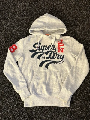 Superdry hoodie~sällsynt  - Säljer nu denna väldigt eftertraktade superdry hoodien. Skick 8/10, sjukt snygg och unik. Denna blir såld fort så skynda! Obs går ner i pris vid snabb affär! 