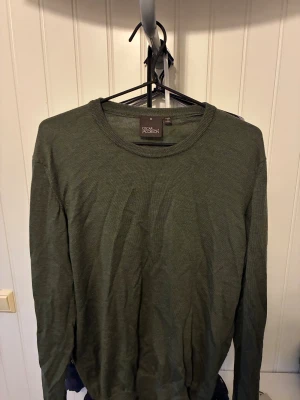 Mörkgrön merinoull sweatshirt - En riktigt skön tröja från Oscar Jacobson i materialet merinoull. Tröjan är i en väldigt stilren, neutral grön färg som passar perfekt till vardaglig användning eller tillsammans med mer uppklädda plagg. Tröjan är i storlek M men sitter mer som en S. Vid funderingar eller fler bilder är det bara att skriva.