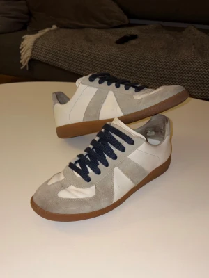 Maison margiela gats - Säljer nu min Mason matgiela gats då de börjar blå små. De är i storlek 42 men skulle personligen säga att de sitter mer som 43. Har bytt ut original snöre mot ett lite tjockare Bach blått snöre för att få lite häftigare, poppande och personligt utseende. Skorna är lite slitna i hälarna där av det bra priset!!!! Kom med bud och skriv gärna om ni har frågor!!!  