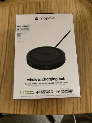 Mophie Wireless Charging Hub - Universal trådlös laddningshub med USB-A och USB-C portar. Laddar upp till fyra enheter samtidigt, stödjer upp till 10W trådlös snabbladdning och fungerar med alla Qi-kompatibla smartphones. Laddar även genom tunna skal. Förpackningen har en liten reva men produkten är ny.