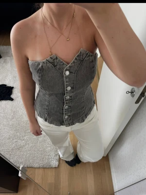 Grå denim korsett från Gina Tricot - Supersnygg grå korsett-topp i denim från Gina Tricot x Hanna MW. Kanske använd nån gång, finns antagligen inte kvar att köpa. 