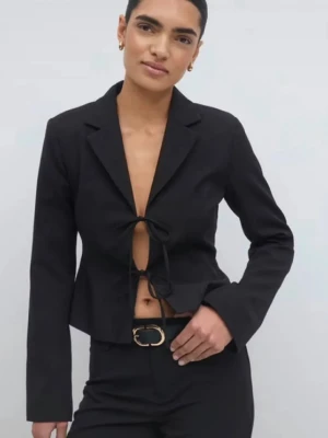 Svart croppad kavaj med knyt från Gina Tricot  - Snygg svart croppad kavaj med knyt framtill och klassisk krage i nyskick. Kavajen har lång ärm och en stilren, figurnära passform som ger en modern look. Ny pris 599kr från Gina Tricot. 