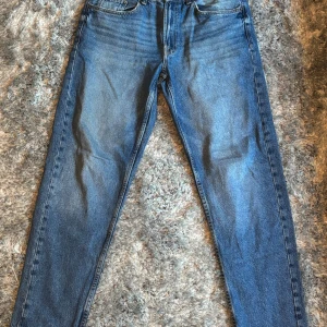 Blå straight vintage jeans från Bershka - Säljer ett par blåa straight vintage jeans från Bershka. Klassisk femficksmodell med raka ben och normal passform. Jeansen är i denim och har en snygg tvättad look som ger en retrovibe. Perfekta till sneakers eller boots.