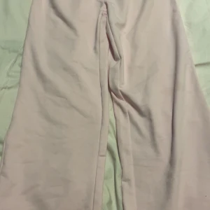 Ljusrosa vida mjukisbyxor - Supermjuka och sköna ljusrosa mjukisbyxor med bred resår i midjan och riktigt avslappnad passform. Byxorna har raka, vida ben och är perfekta för en chill och avslappnad stil. Passar dig som gillar bekväma och trendiga plagg.