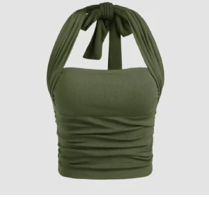 Olivgrön ribbad halterneck topp - Snygg olivgrön croppad topp med breda axelband som knyts i nacken. Toppen är ribbad och har en åtsittande passform som framhäver figuren. Perfekt för dig som gillar trendiga och bekväma plagg med det lilla extra. Skriv gärna vid frågor!🤗