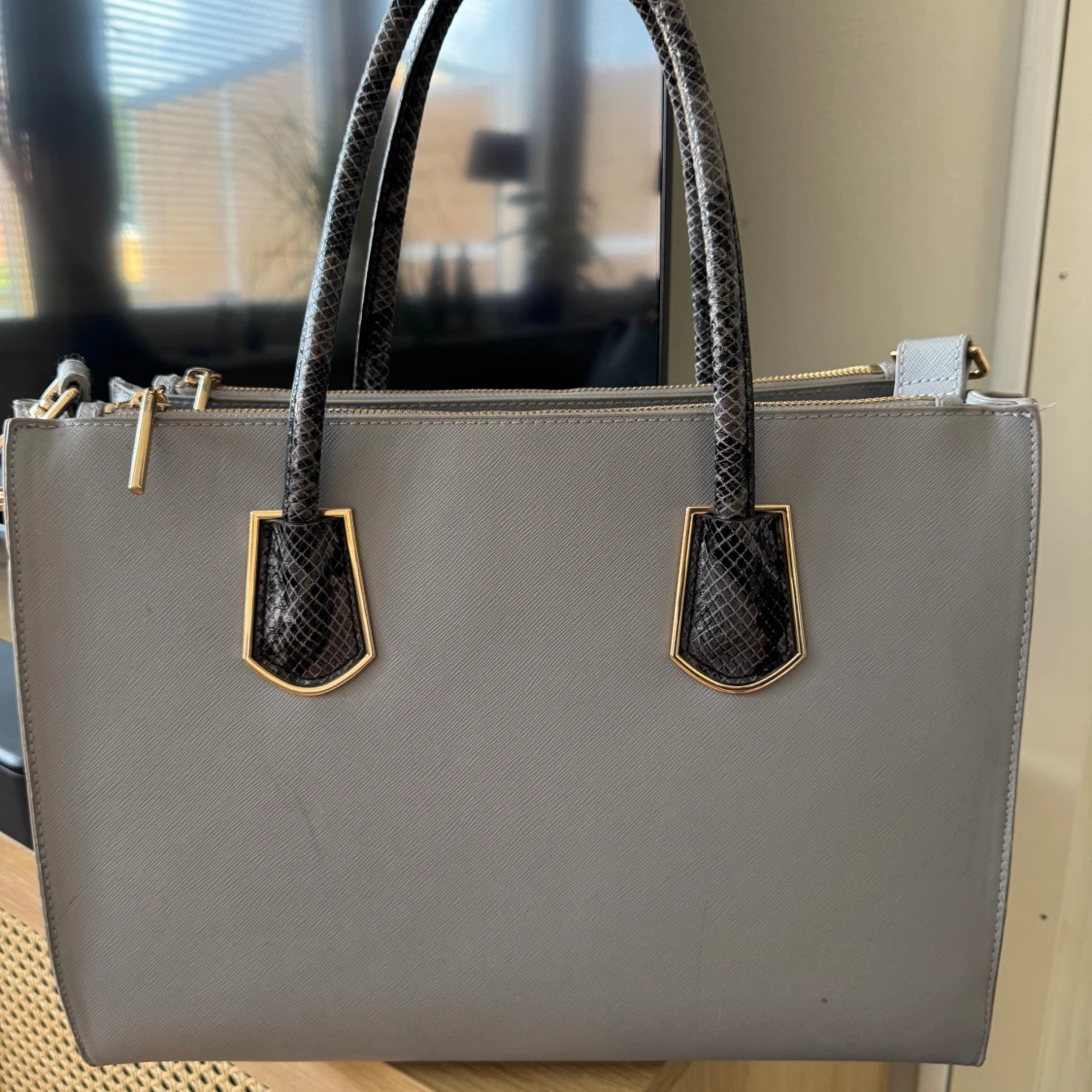 Grå handväska med ormmönstrade handtag