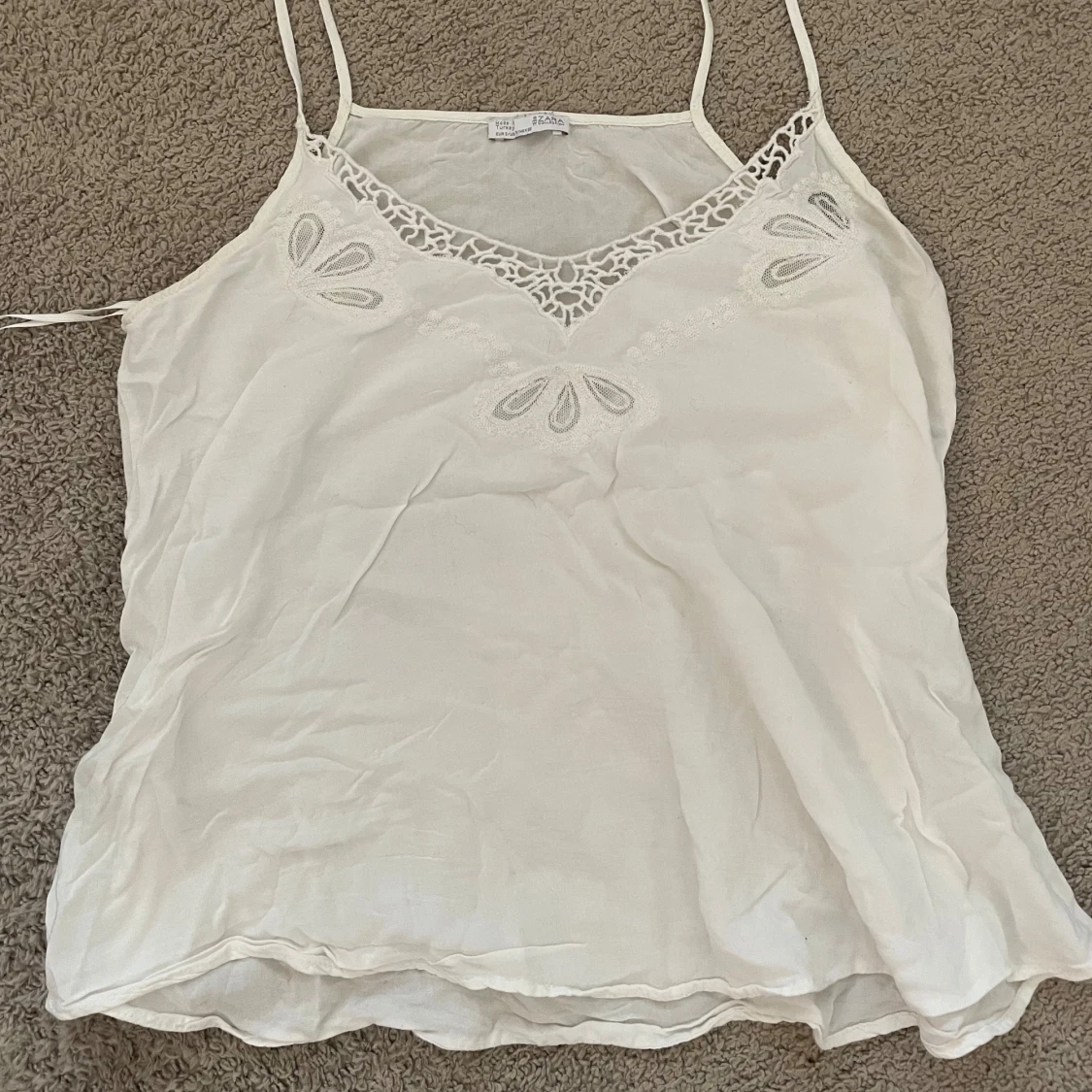 Vit linnetopp med spetsdetaljer