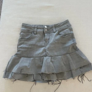 Grå Volangkjol - Säljer en jättesöt volangkjol som jag sytt om från ett par jeans i storlek 146 men passar även för 152. Säljer då den inte passar längre. 