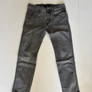 Replay grå skinny jeans - Snygga grå jeans från Replay med skinny passform. Jeansen har klassisk femficksdesign, svarta detaljer och diskret Replay-logga på bakfickan. Tillverkade i stretchigt jeanstyg för en bekväm känsla och tight look. Liten reva höger bakficka.
