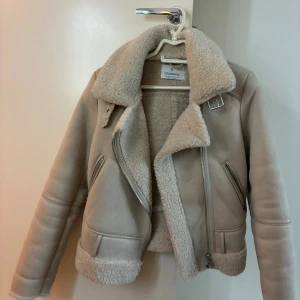 Beige teddyjacka från Stradivarius XS - Säljer en beige teddyjacka från Stradivarius i storlek XS. Jackan har mjukt teddyfoder, bred krage och detaljer med dragkedjor framtill. Perfekt för att hålla sig varm till höst och vinter!🤩