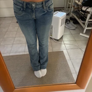 Blå bootcut jeans från Gina Tricot - Säljer ett par klassiska blå bootcut jeans från Gina Tricot i storlek 170. Jeansen har en snygg tvätt, fem fickor och normal passform. Perfekta om du gillar en tidlös look med lite utsvängda ben. Materialet är jeans med skön stretch.