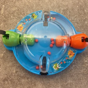 Roligt spel - Det här är ett färgglatt och roligt spel med två hungriga flodhästar som tävlar om att äta flest röda bollar. Perfekt för dig som gillar snabba och actionfyllda utmaningar tillsammans med vänner! Spelet är kompakt och lätt att ta med sig överallt.