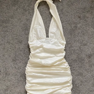 Vit omlottklänning från Gina Tricot - Supersnygg vit kortklänning från Gina Tricot i glansigt satinmaterial. Endast använd en gång så den är som ny!💌