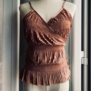 Satin omlott linnetopp från zara - Säljer en omlott-linnetopp med smala axelband och volangkant.